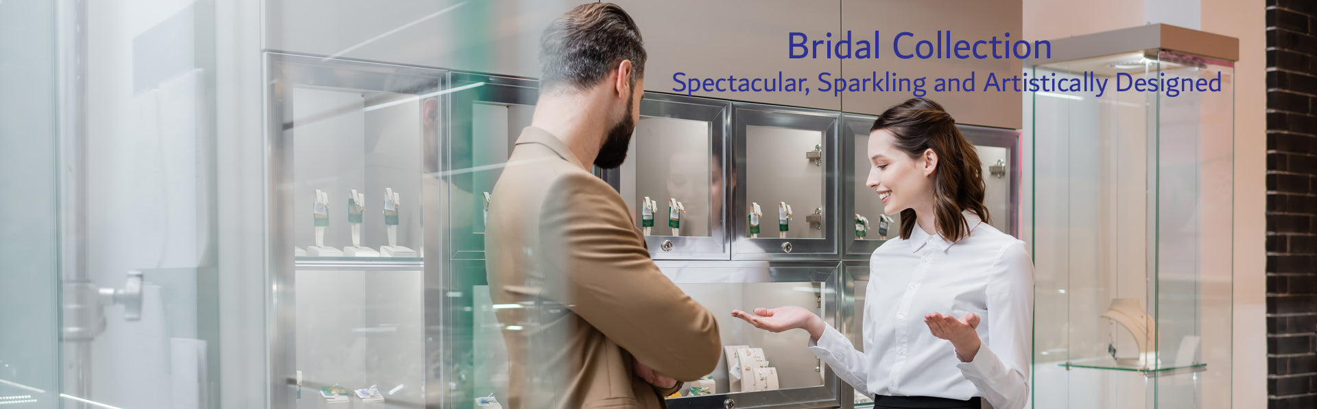 Two people in a jewelry store are looking at jewelry display cases with 'Bridal Collection.