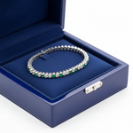 14k gold round diamond and emerald tennis bracelet with 3.86 carats total weight, displayed in a royal blue jewelry box.