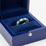 14k gold green emerald diamond eternity wedding band with 3.57 carats total, showcased in a royal blue box.