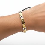 14k solid gold round diamond tennis bracelet with 0.99 ct tw, worn on male model, showcasing two-tone gold design and sparkling diamonds.
