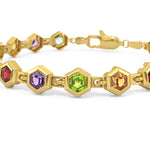 Gold bracelet with colorful gemstones on a white background