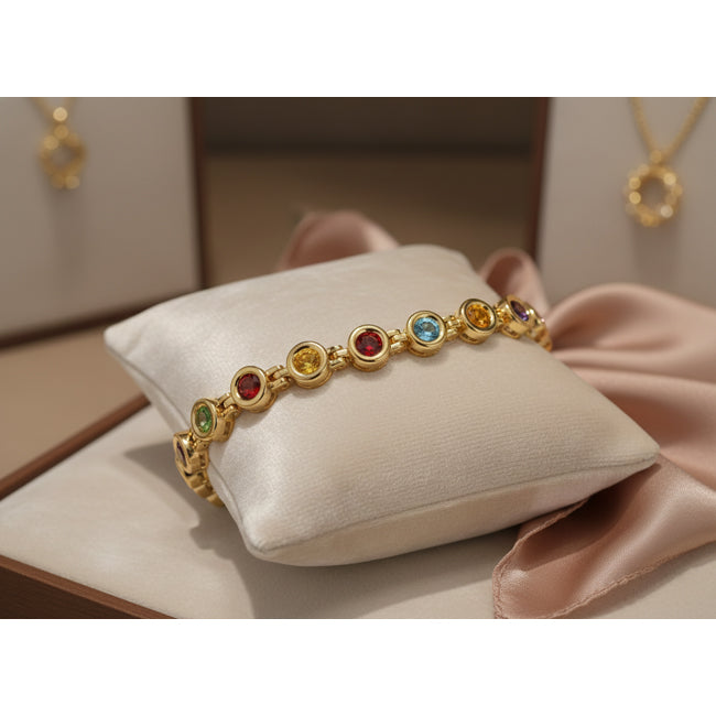 Gold bracelet with colored gemstones on a white cushion
