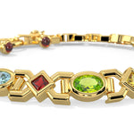 Gold bracelet with various colored gemstones on a white background