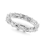 Diamond ring with emerald-cut iamonds on a white background
