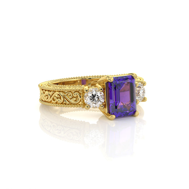 A yellow gold ring featuring a rectangular emerald-cut velvet tanzanite center stone, flanked by two round-cut clear diamonds, set against a clean white background with a soft reflection.