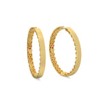 Gold hoop earrings with intricate design on a white background