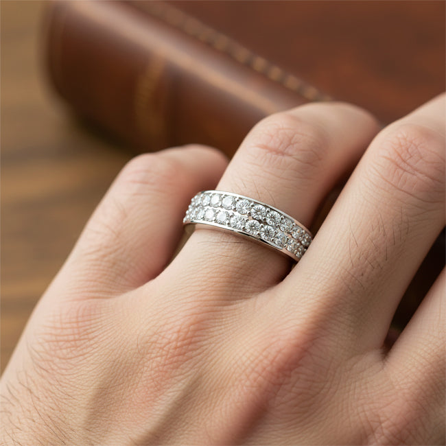 Gold Band with diamonds on a finger against a wooden background