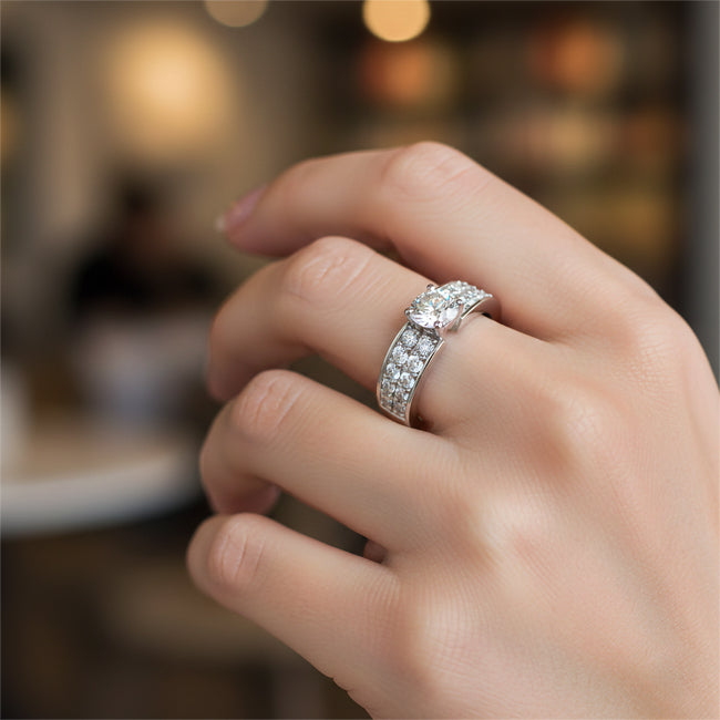 Close-up of a hand wearing a diamond ring with a blurred background