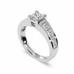 A princess-cut diamond engagement ring in a polished white-colored metal band with a channel-set row of diamonds on the shank, shown on a clean white background.