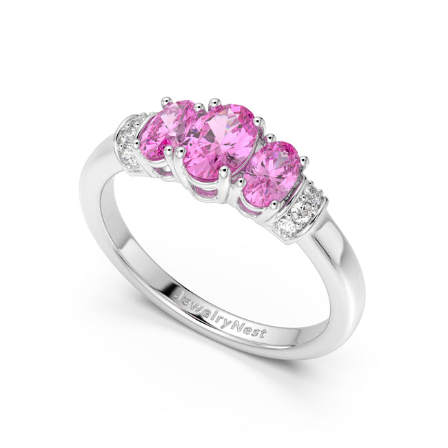 Silver ring with pink gemstones on a white background