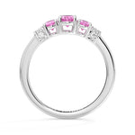 Silver ring with pink gemstones on a white background