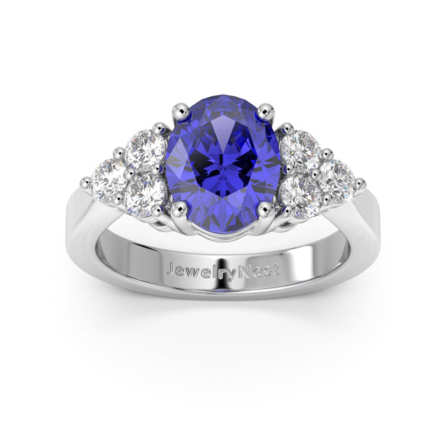 Ring with a blue gemstone and diamonds on a white background, branded 'JewelryNest'.