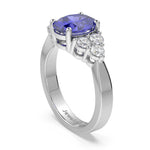 Gold ring with a purple gemstone and diamond accents on a white background