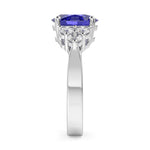 Gold ring with a blue gemstone and clear stones on a white background