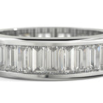 A close-up of a white-toned ring featuring a row of clear baguette-cut gemstones set in a polished band, shown against a white background.