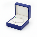 Diamond emerald station bracelet on royal blue wooden box