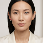 Full-face model wearing yellow-gold ruby and diamond stud earrings