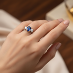 14k gold three-stone sapphire and diamond fashion ring on hand, showcasing elegant jewelry with sparkling gemstones.